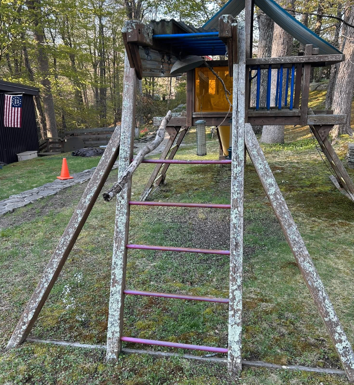 Same wooden playground after pressure washing, with clean bare wood and the lichen removed.